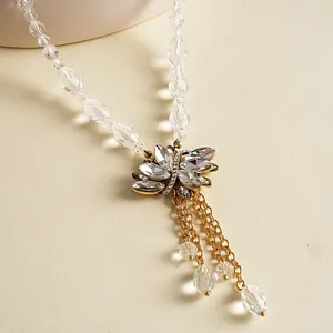 Gedetailleerde opname van een elegante ketting met bladhangers en gouden kettingkwastjes