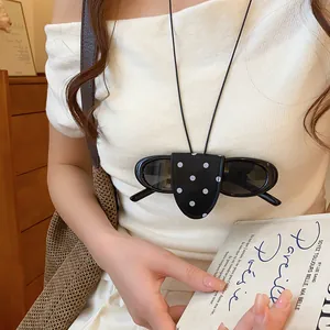 Chique retro lederen zonnebrilhouder ketting met stippen gedragen als modeaccessoire