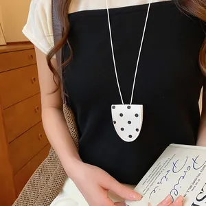 Detailweergave van een witte vintage polka dot brillenclip ketting op een top