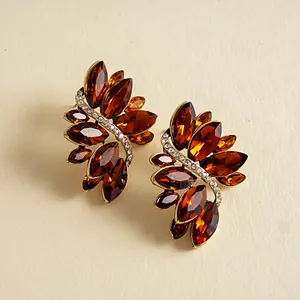 Macro-weergave van vintage bladvormige oorbellen met amberkleurige glasstenen en steentjes