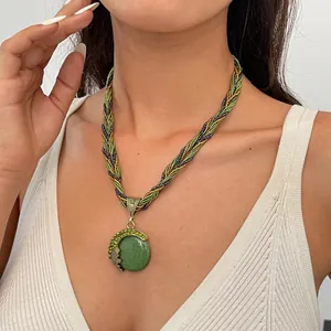 Detailopname van een vintage groene hars hanger ketting gedragen door een model