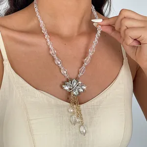 Detailopname van elegante bladkwastjesketting met heldere glaskristallen en gouden ketting