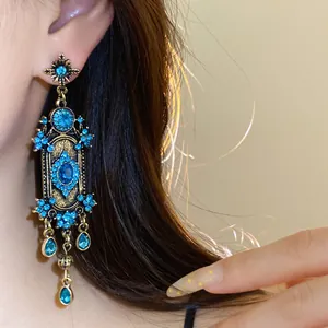 Gros plan de boucles d'oreilles pendantes bohèmes vintage avec strass bleu vif