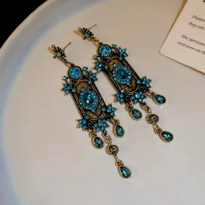 Détail de boucles d'oreilles bohèmes vintage avec strass bleus et pampilles gouttes