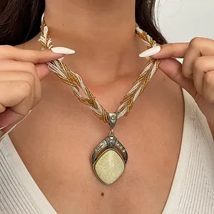 Macro-opname van een vintage hars druppelhanger ketting met gevlochten kralenkoord en strass