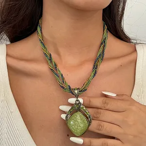 Detailopname van een vintage ketting met een groen gemarmerde hars hanger in de vorm van een druppel