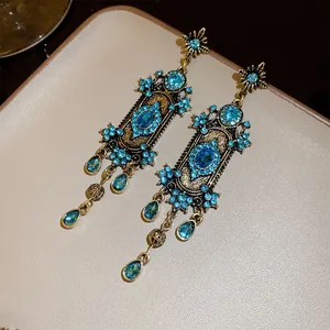 Vue détaillée de boucles d'oreilles bohèmes vintage avec strass bleus et des glands