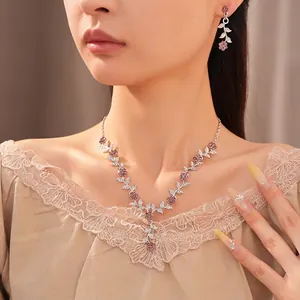 Elegantes Schmuckset mit silbernen Blättern und lila Kristallen an einem Modell.