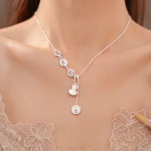 Close-up detail of a silver necklace featuring Fu character charms and a shell gourd pendant