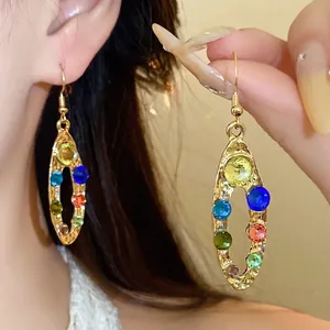 Elegantes pendientes ovalados con cristales de colores y acabado en oro martillado