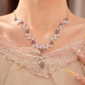 Close-up of palace style necklace with purple floral and leaf rhinestone detail
