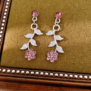 Detailed view of elegant pink flower and leaf stud earrings with silver-tone finish