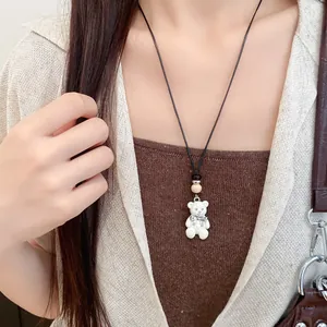 Primo piano della collana con pendente a forma di orsetto in resina bianca su modella