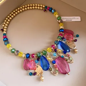 Gros plan d'un collier ras du cou en perles d'acrylique avec de grands pendentifs