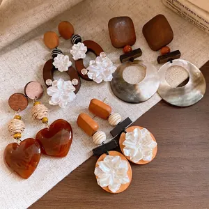 Pendientes vintage hechos a mano de madera y concha con flores y corazones