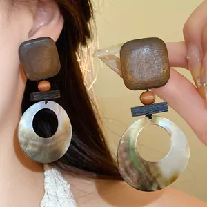 Detailansicht der Vintage-Ohrringe aus Holz und Muscheln in geometrischen Formen