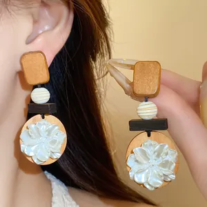 Detailansicht von Retro-Holzohrringen mit filigranen Muschelblumendetails für Damenmodeschmuck