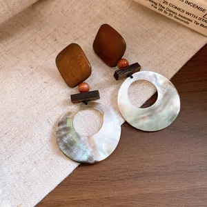 Detail von Vintage-Ohrringen im neuen chinesischen Stil mit Holz und Muschel-Dekor