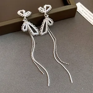 Detail view of silver butterfly tassel earrings featuring delicate pearl inlay and long chains