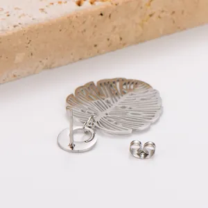 Macro detail of stainless steel hollow monstera leaf stud earring and silver backing