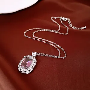 Nahaufnahme eines eleganten ovalen lila Edelsteinanhängers auf dunkelrotem Satinhintergrund