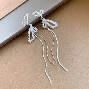 Detailed view of silver butterfly tassel earrings with delicate pearl inlay