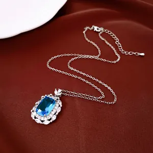 Nahaufnahme einer eleganten Silberkette mit großem blauem Zirkonia-Anhänger.
