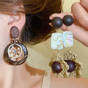 Detailed view of handmade Bohemian wood and coconut shell drop earrings for women.