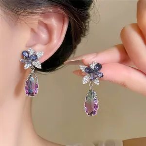Detailansicht eleganter Ohrstecker mit violettem Farbverlauf und silbernen Ziersteinen.