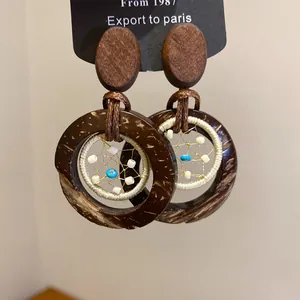 Close-up of boho vintage wood and coconut shell beaded round drop earrings.