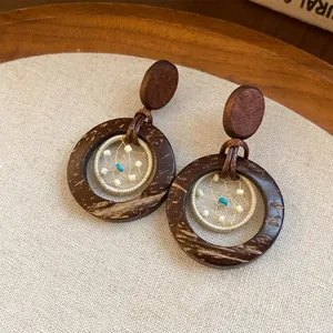Detailed view of boho earrings made from coconut shells and beads.