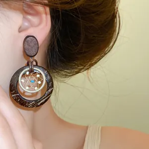 Close-up detail of vintage Bohemian style wood and coconut shell dreamcatcher drop earrings