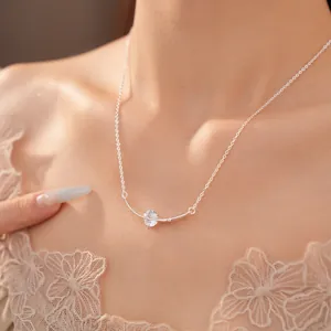 Close-up detail of a silver curved bar necklace featuring a brilliant round zircon stone.
