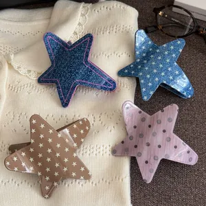 Set of 4 star-shaped acetate hair claw clips with denim and polka dot patterns.