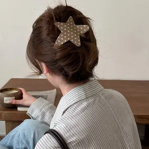 Close-up of a stylish star-shaped acetate hair clip worn on back of head