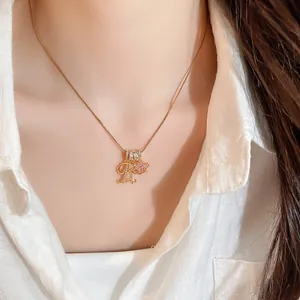 Gros plan d'un collier plaqué or 18k avec pendentif lettre R et gemme rose coeur