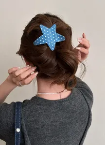 Detailed view of a blue star-shaped hair clip with white star patterns on model