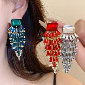 Détail de boucles d'oreilles en strass en forme d'éventail en vert, rouge et argenté