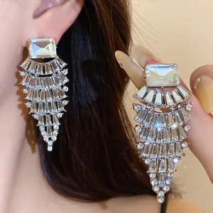 Vue détaillée de boucles d'oreilles pendantes argentées en forme d'éventail avec cristaux.