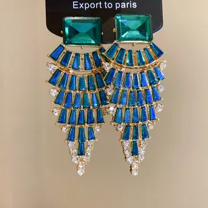 Vue détaillée de boucles d'oreilles en éventail avec strass verts et bleus brillants