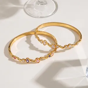 Detailansicht goldener Edelstahlarmreifen mit bunten eingelegten ovalen Zirkoniasteinen