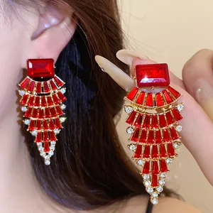 Gros plan détaillé de boucles d'oreilles rouges en éventail avec des éclats de zircone.