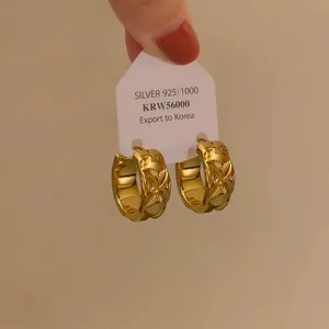 Detailansicht von 18K vergoldeten Creolen mit gesteppter Diamant-Rautenstruktur.