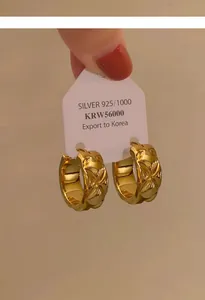 Nahaufnahme von 18 Karat vergoldeten Creolen mit einer klassischen Steppstruktur.