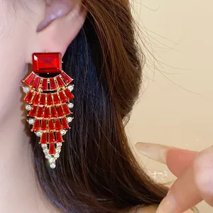 Gros plan détaillé de boucles d'oreilles éventail en cristal rouge avec accents dorés