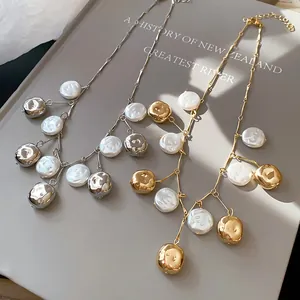 Detailansicht von Gold- und Silberketten mit Barockperlen und metallischen Anhängern.
