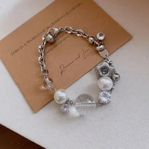 Vue détaillée d'un bracelet en argent élégant avec perles, cristaux et pendentif fleur