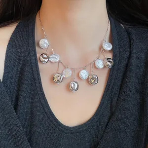 Detailaufnahme einer minimalistischen Perlenhalskette mit silberfarbenen Metallakzenten.