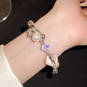 Gros plan d'un bracelet en zircon et perles avec pendentif fleur au fini luxueux.