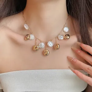 Detailansicht einer eleganten goldenen Quastenkette mit Perlenscheiben am Model.